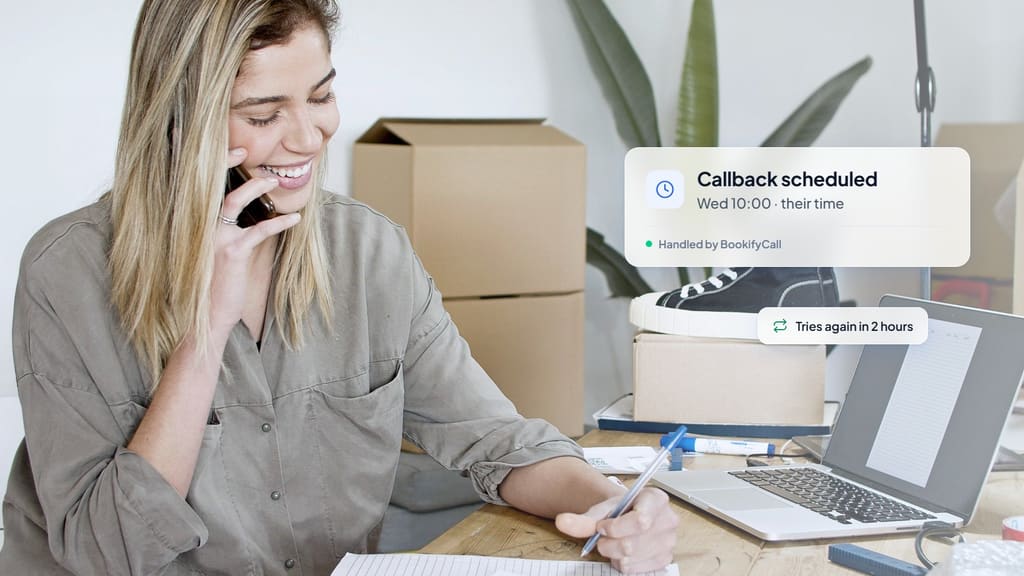 Small business owner smiling on a phone call at her desk beside a laptop, with a card showing a callback scheduled for Wednesday at 10:00 in the contact's time