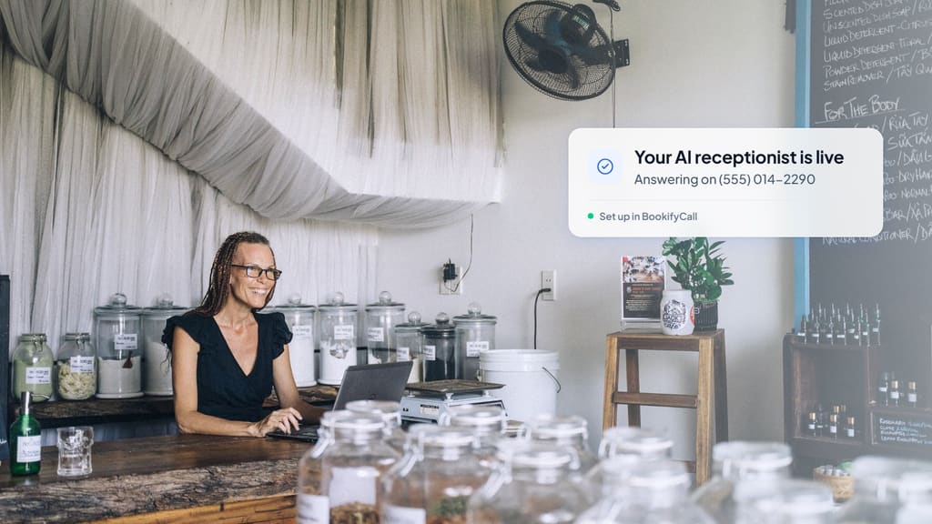 Shop owner working on a laptop behind her counter, with a card showing her AI receptionist is live and answering on a business number